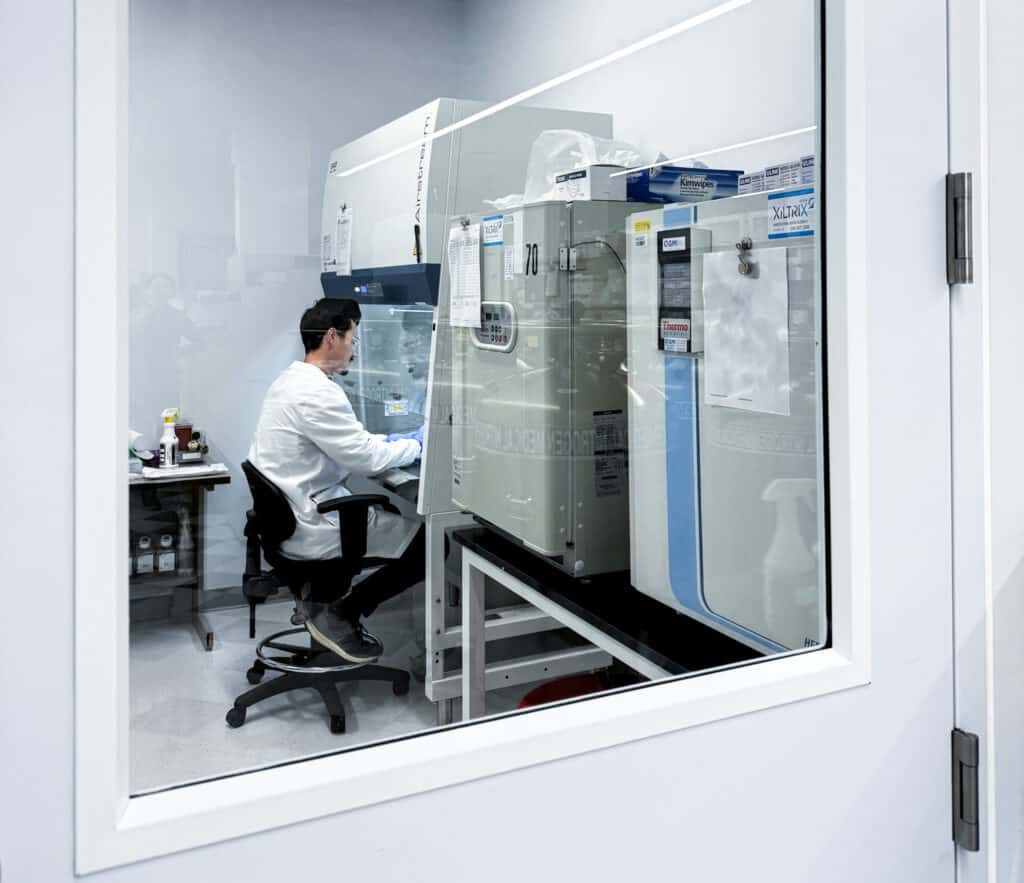 Scientist working in a lab from the view out side of the door.